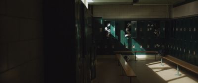 a dimly lit hallway with lockers and benches