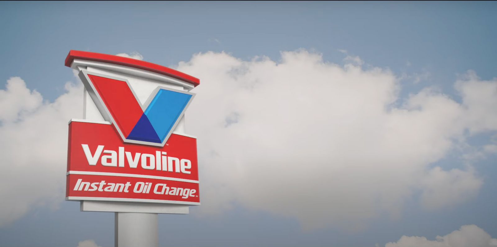 a valvoline sign in front of a cloudy sky