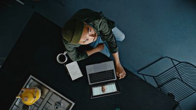 a person sitting at a table with a laptop