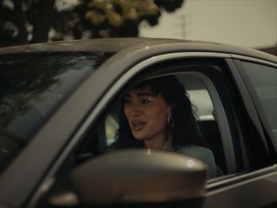 a woman sitting in a car looking out the window