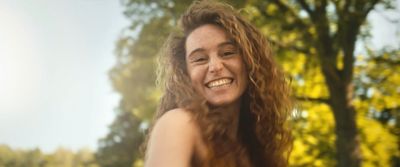 a woman with long hair smiling at the camera