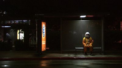 a man sitting on a bench at night