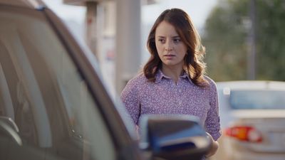 a woman standing next to a parked car