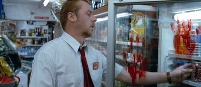 a man in a white shirt and red tie is looking at a refrigerator