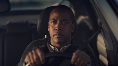 a man sitting in a car holding a steering wheel