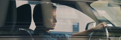 a man sitting in a car with a steering wheel