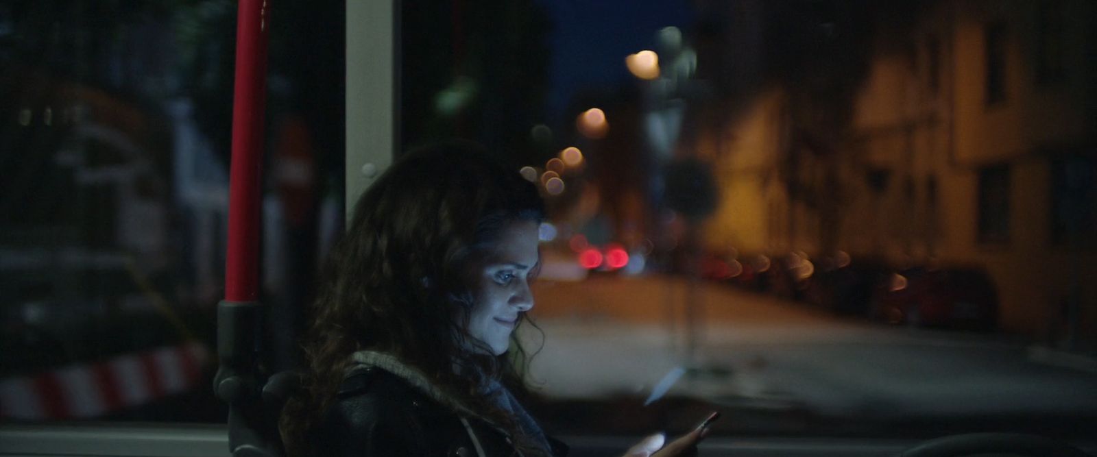 a woman sitting on a bus looking at her cell phone