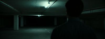 a person standing in a dark parking garage