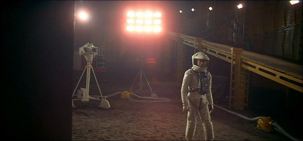 a man in a space suit standing in front of a light