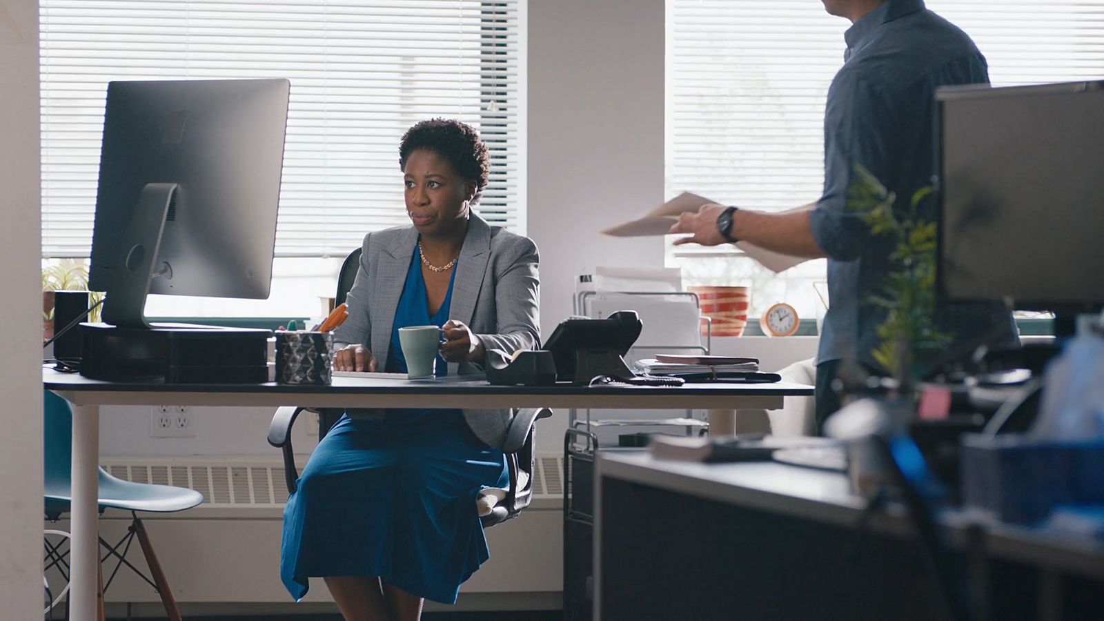 a woman sitting at a desk in front of a computer