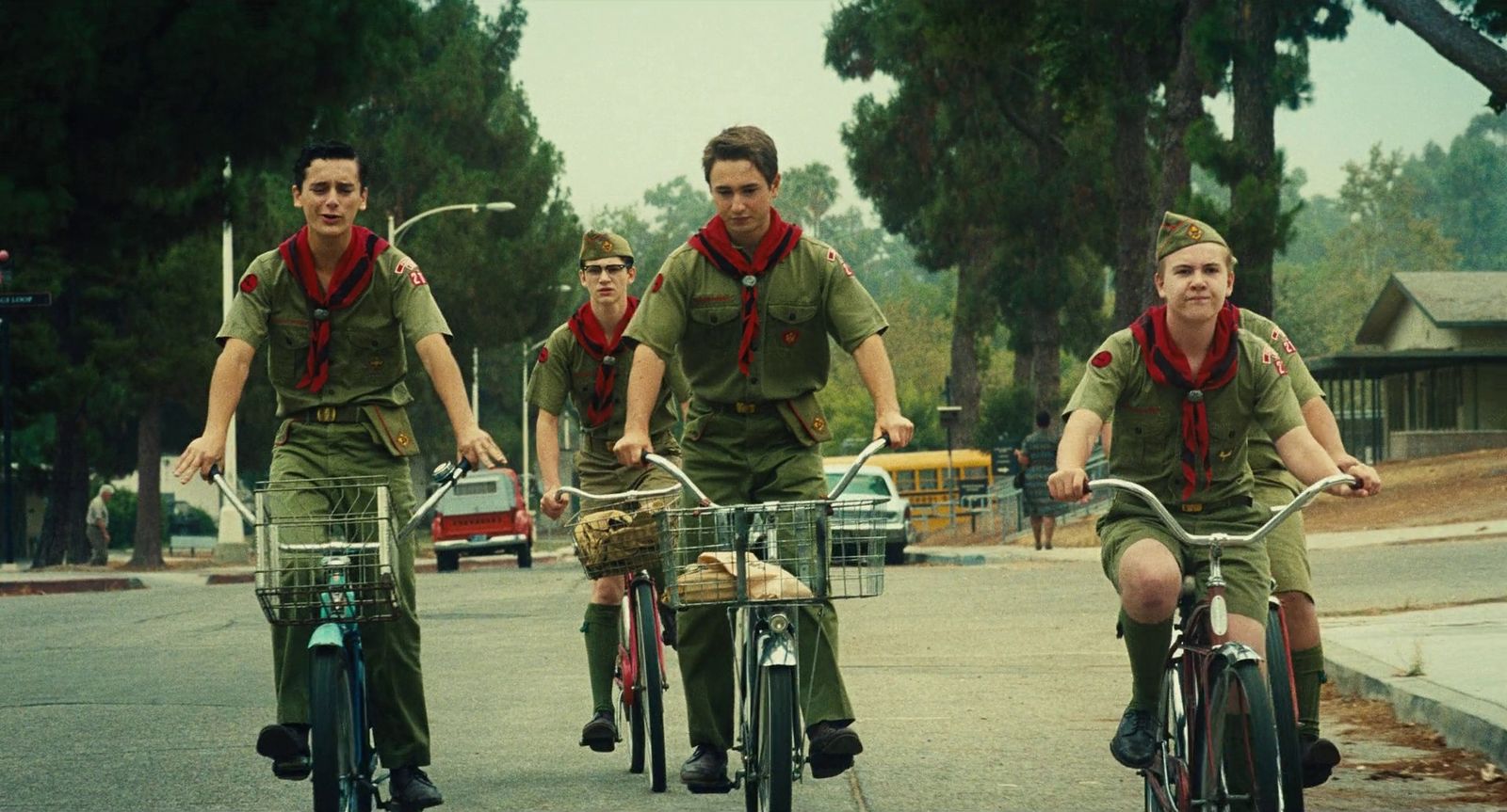 a group of men riding bikes down a street