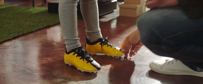 a person sitting on the ground with a pair of yellow shoes