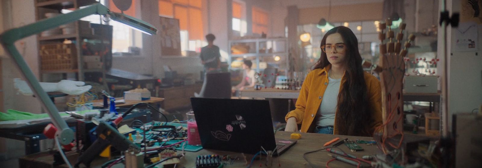 a woman standing in front of a laptop computer