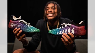 a man sitting on a couch holding a pair of shoes