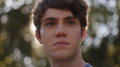 a close up of a person with trees in the background