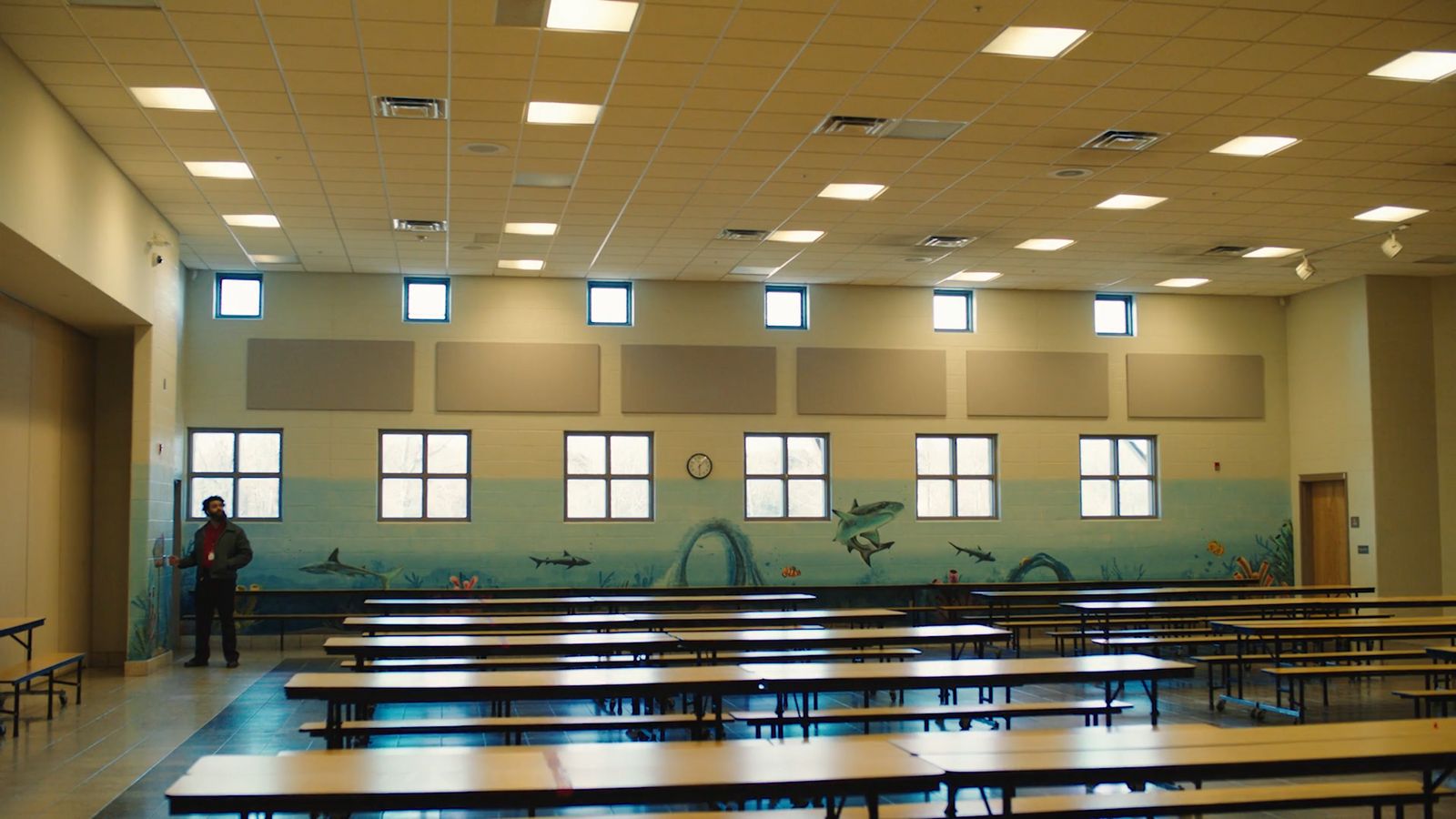 a man standing in front of a classroom filled with desks