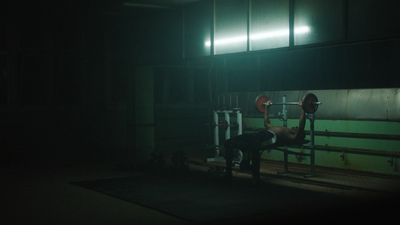 a man doing a bench press in the dark