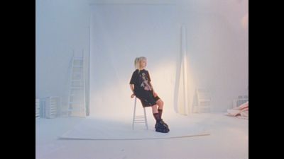 a woman sitting on a chair in a white room