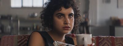 a woman sitting on a couch holding a coffee cup