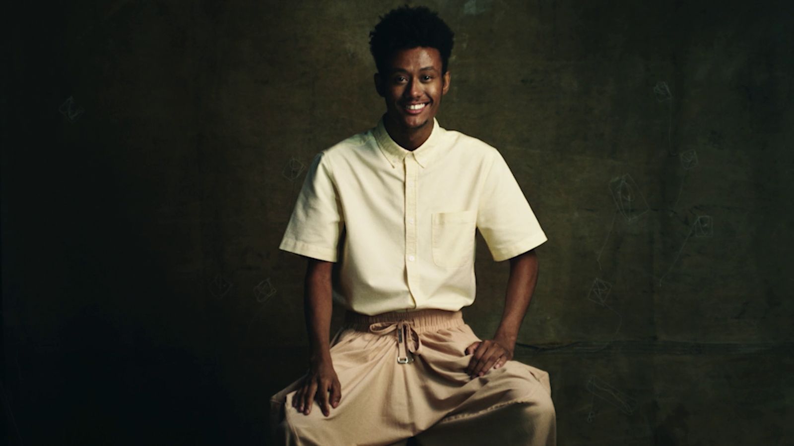 a man in a white shirt and tan pants