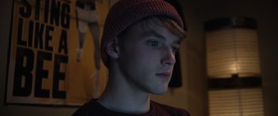 a young man wearing a beanie in a dark room