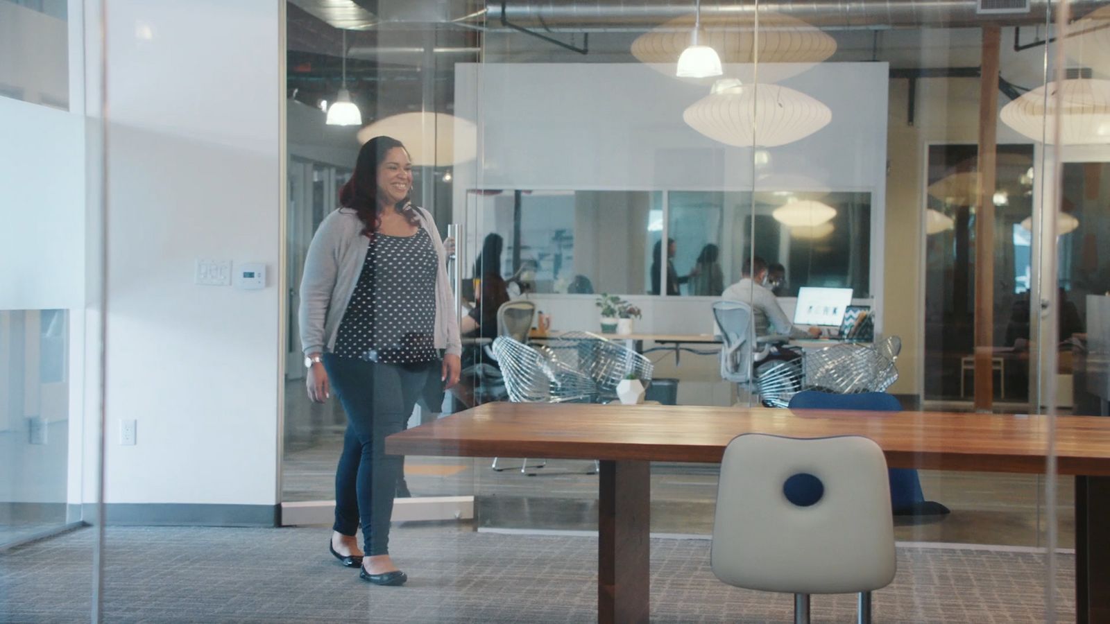 a woman standing in front of a table in an office