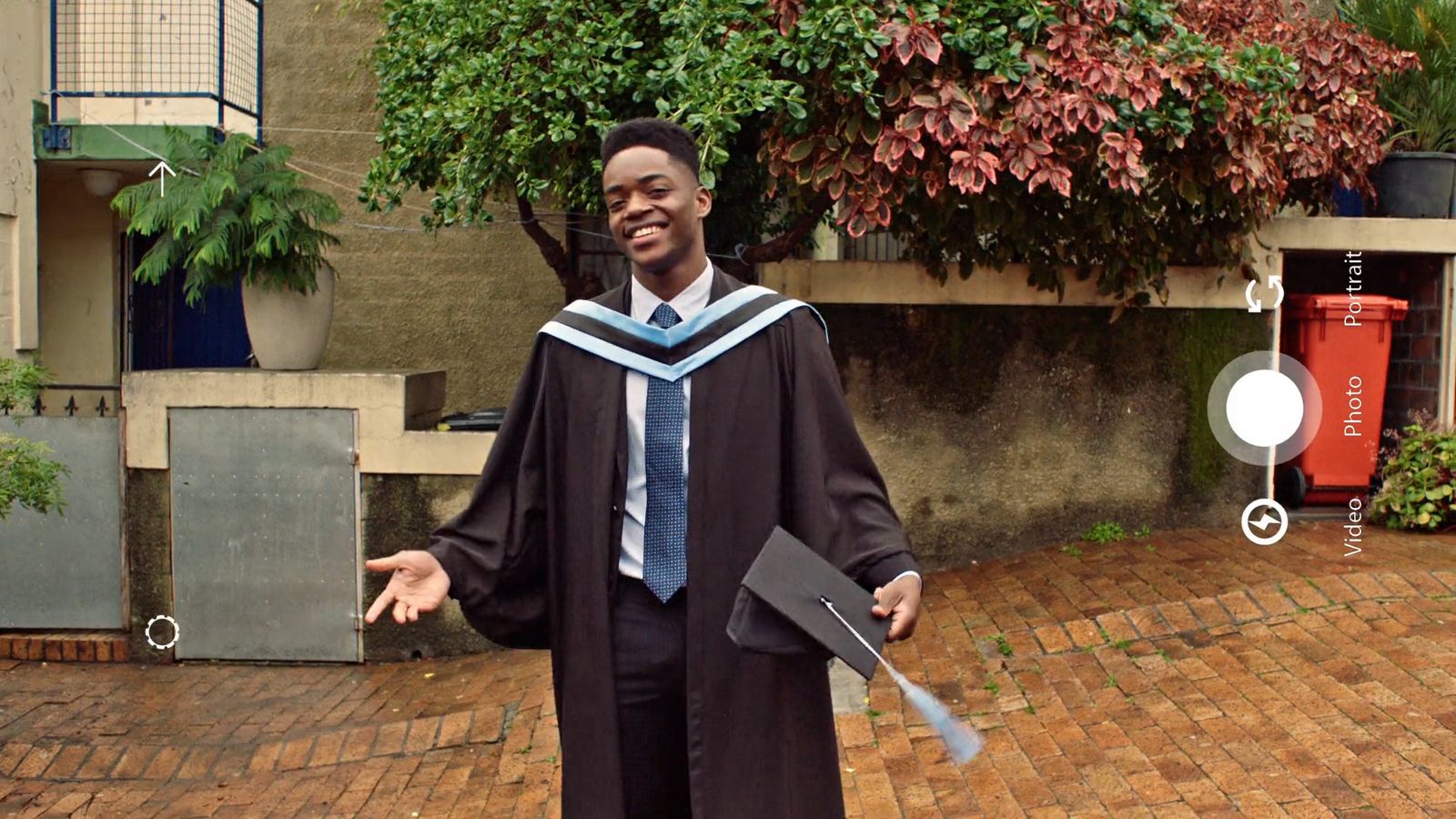 a man in a graduation gown holding a diploma