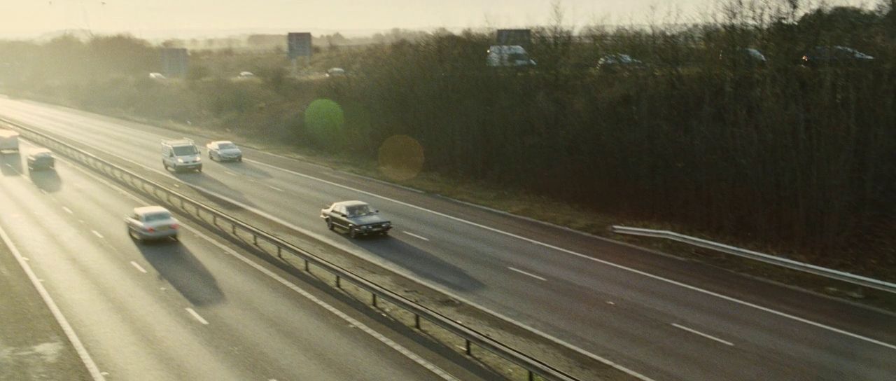 a highway filled with lots of traffic next to a forest