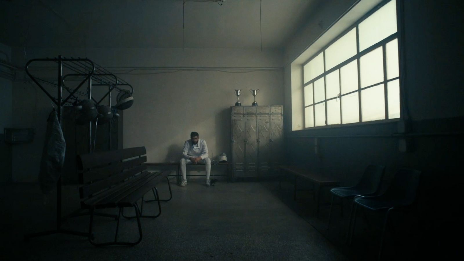 a man sitting on a bench in a dark room