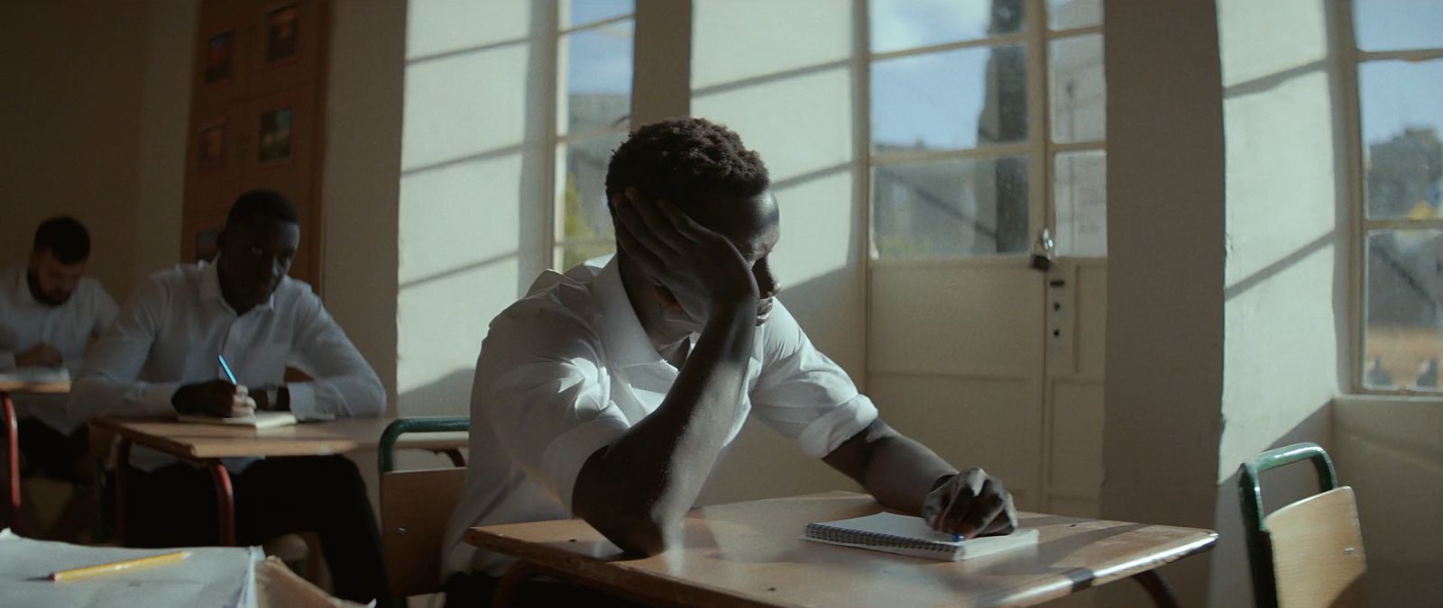 a man sitting at a desk in a classroom