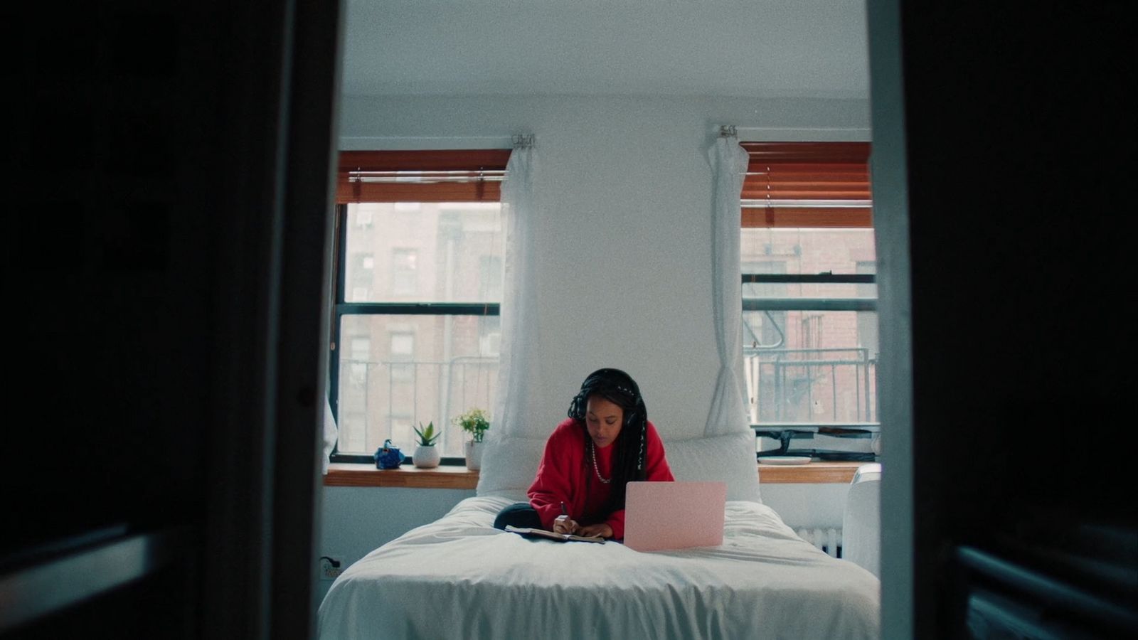 a woman sitting on a bed using a laptop computer