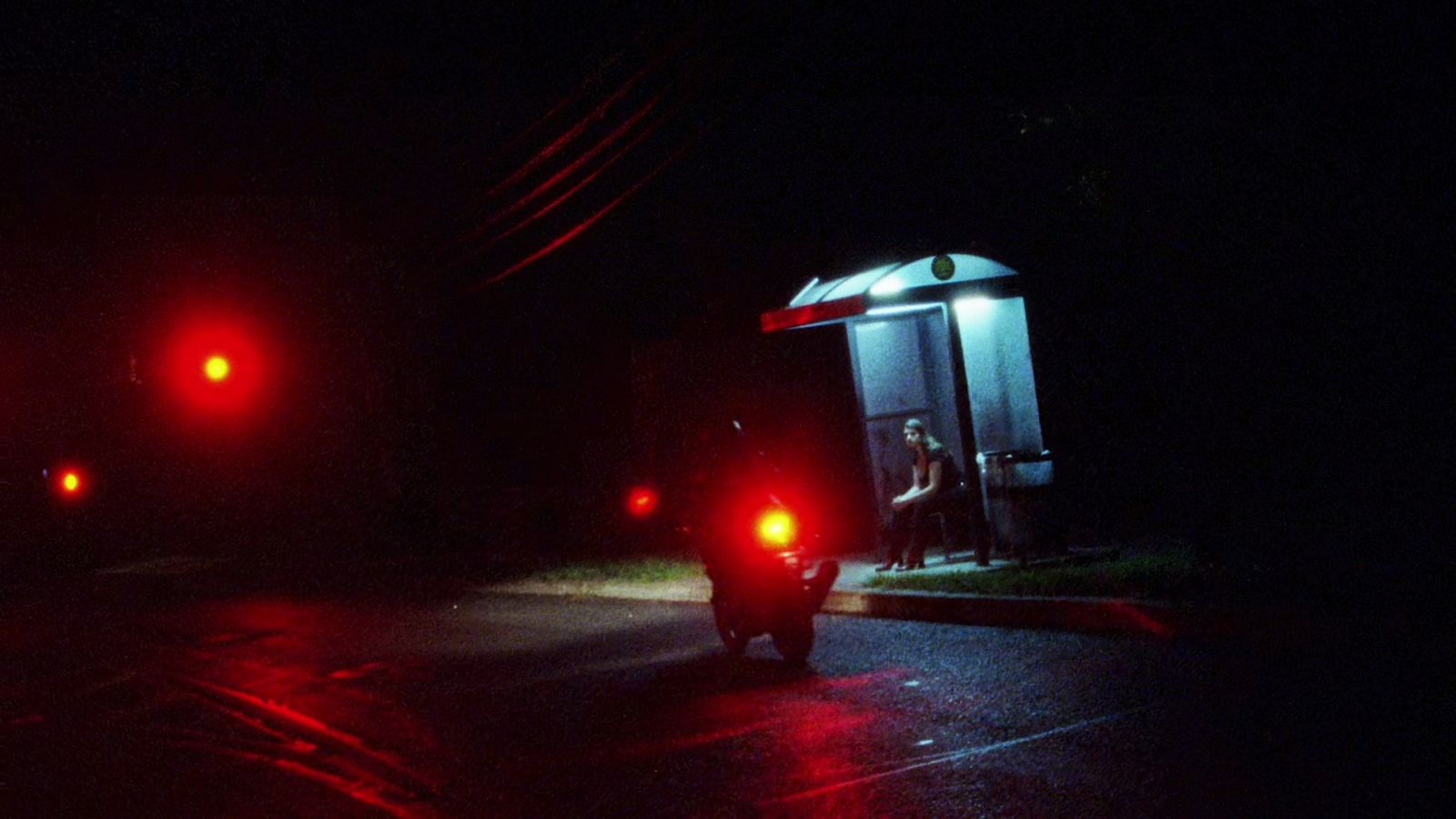 a car stopped at a red light at night