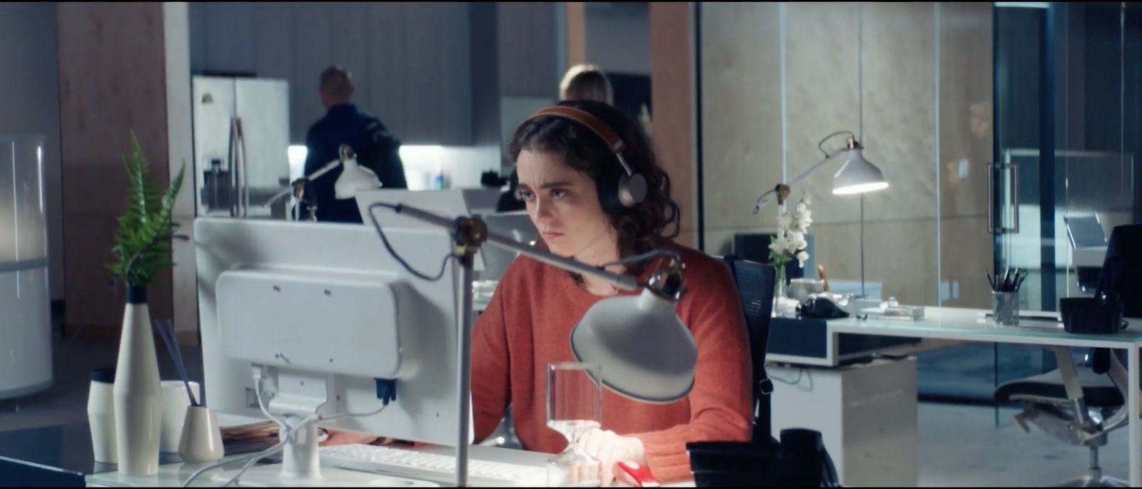 a woman sitting at a desk with headphones on