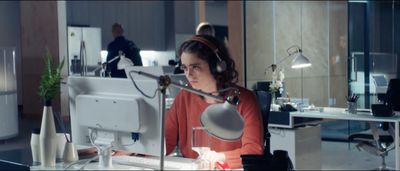 a woman sitting at a desk with headphones on