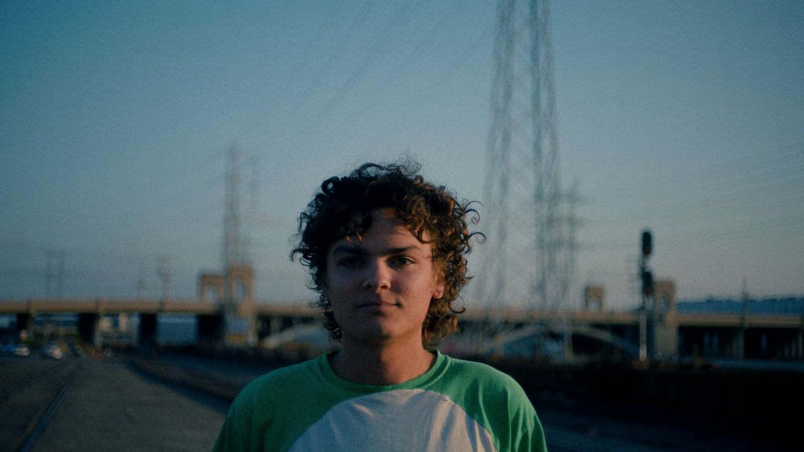 a young man standing in front of a train track