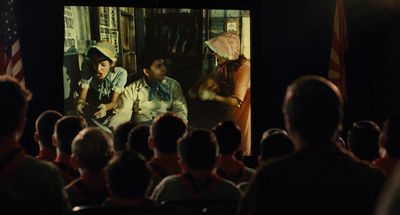 a group of people watching a movie on a large screen