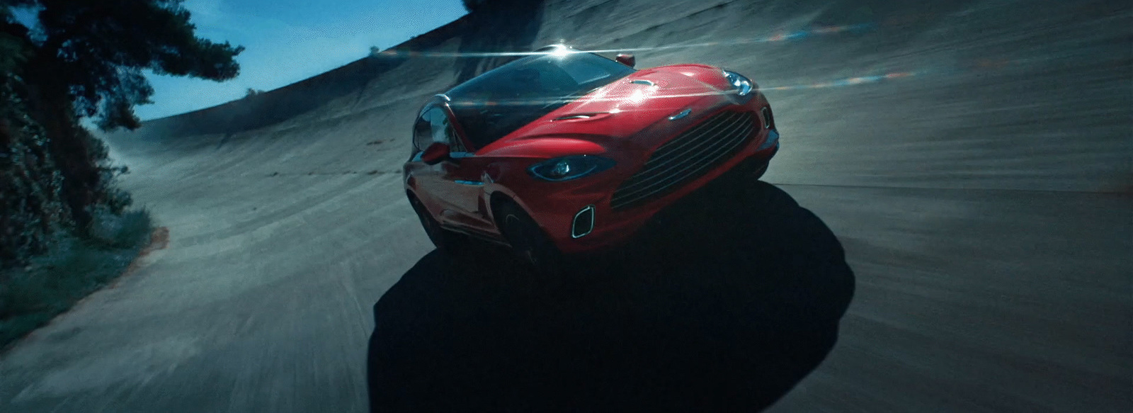 a red sports car driving down a road