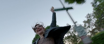 a woman holding a street sign up in the air