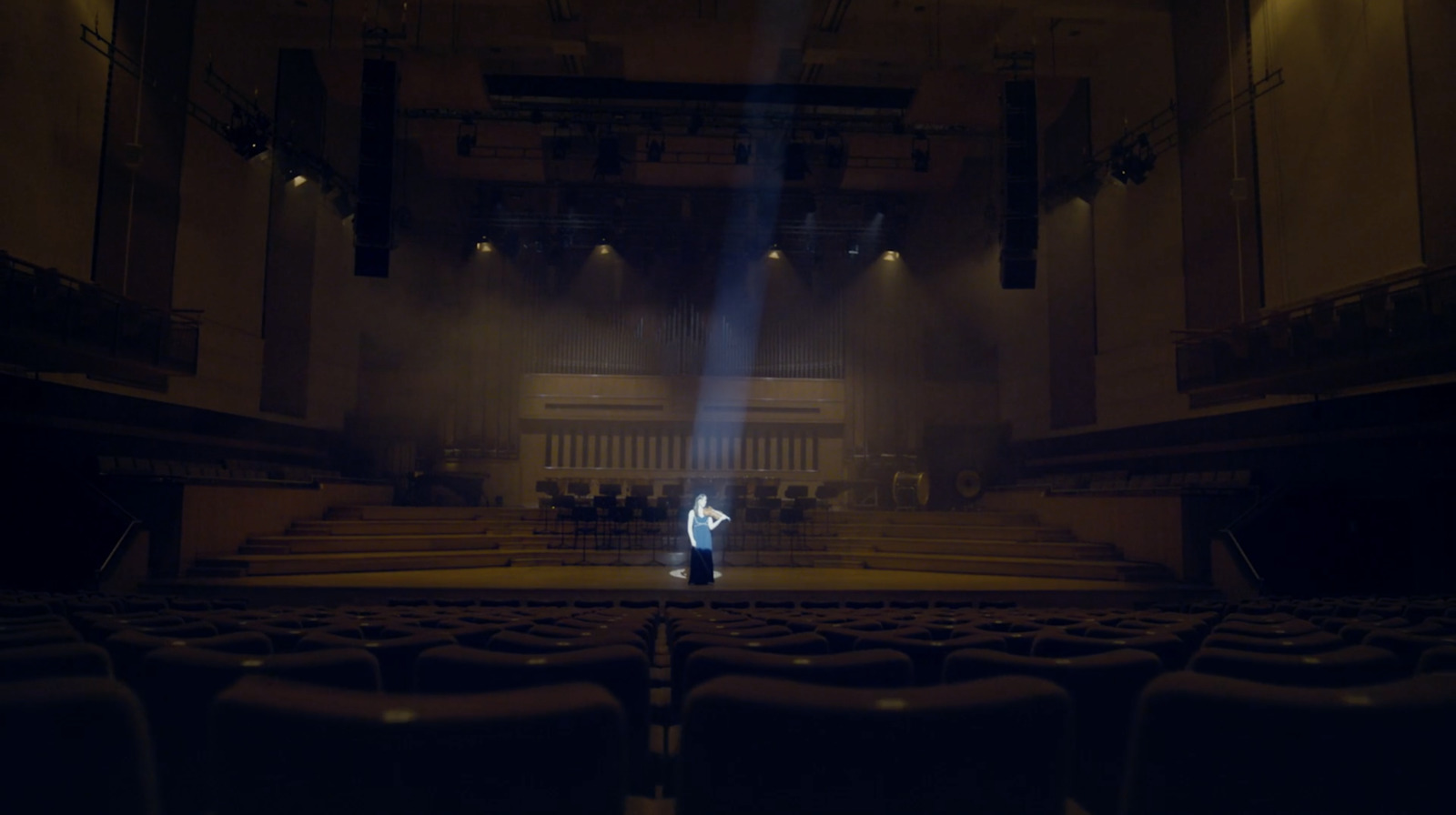 a person standing in front of an empty auditorium