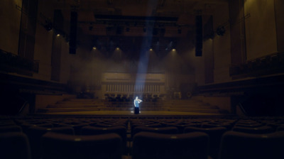 a person standing in front of an empty auditorium