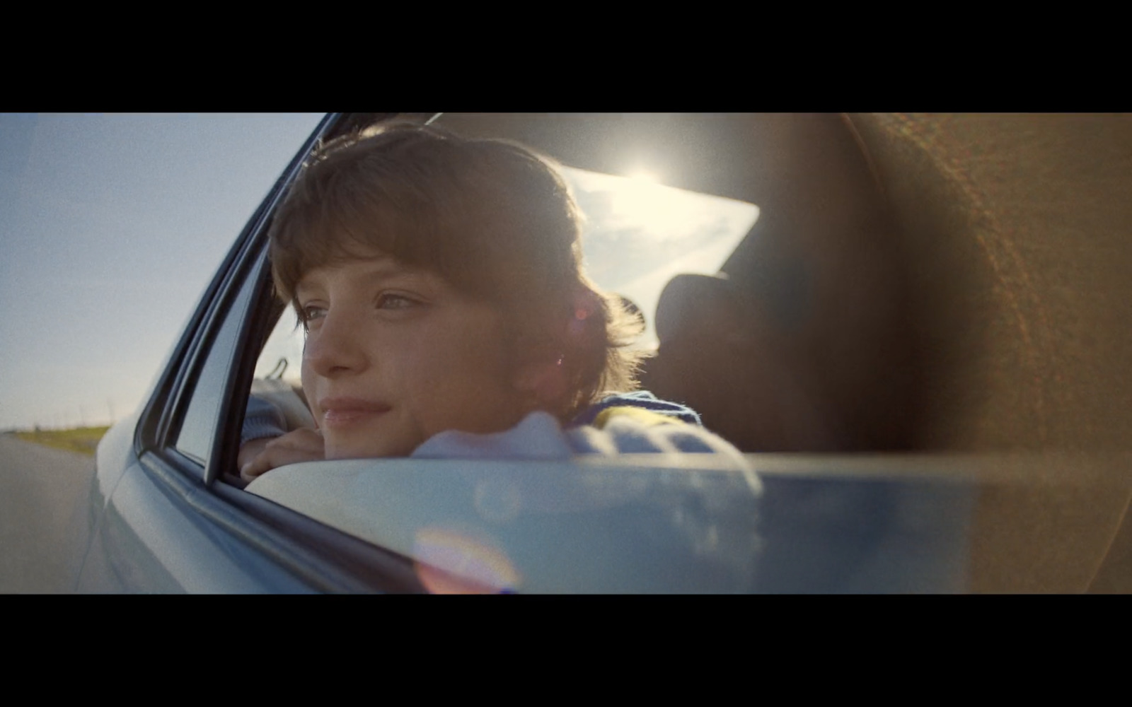 a woman sitting in a car looking out the window