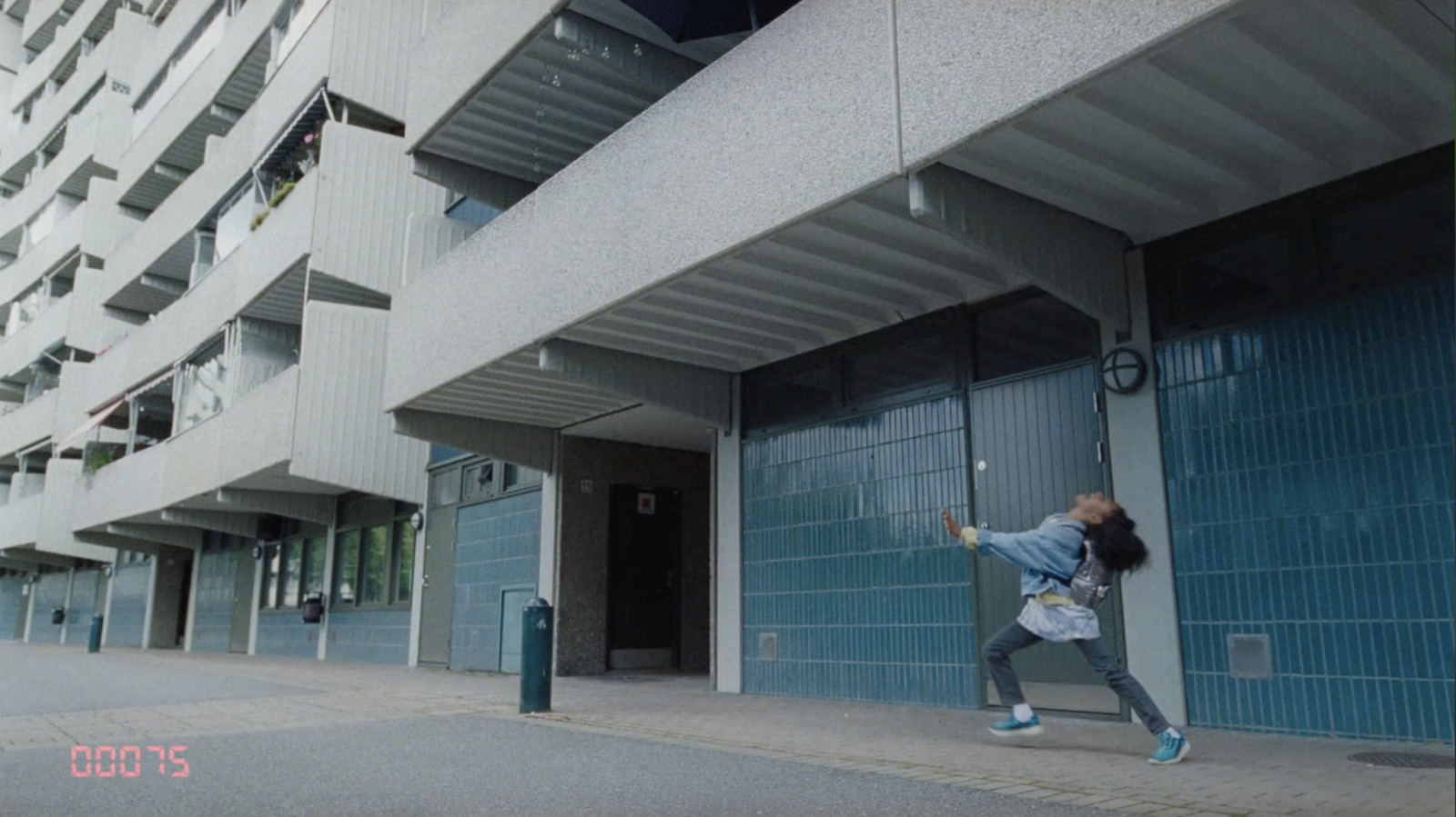 a person jumping up into the air in front of a building