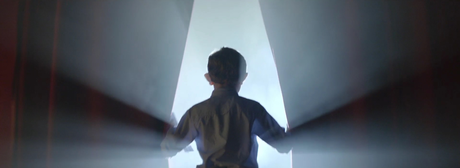 a young boy standing in front of a stage light