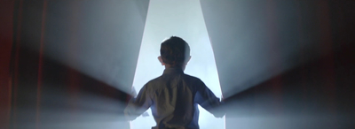 a young boy standing in front of a stage light