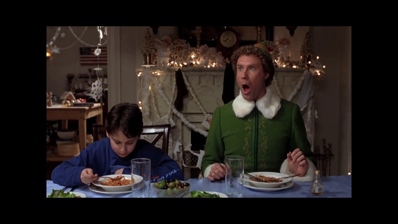 a man and a boy sitting at a table eating food