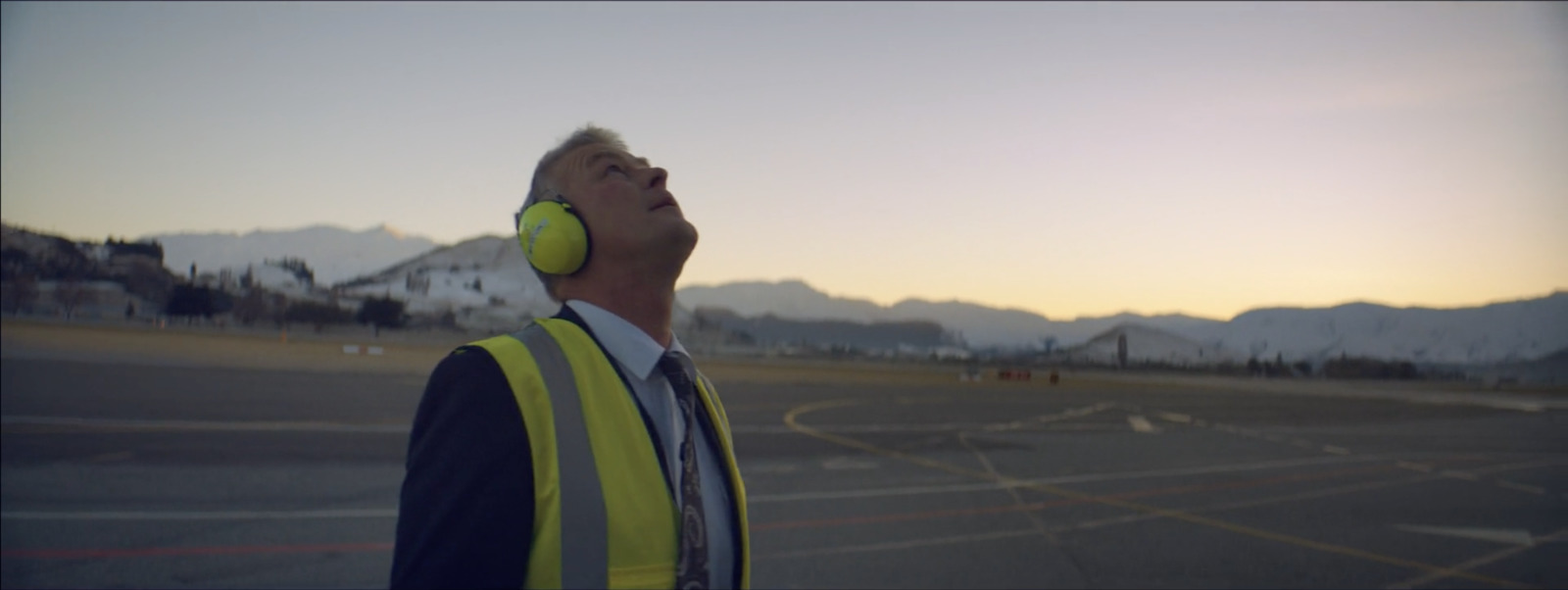 a man wearing a yellow safety vest and headphones