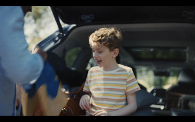 a little boy sitting in the back of a car