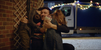 a man and a woman hugging in front of a brick wall