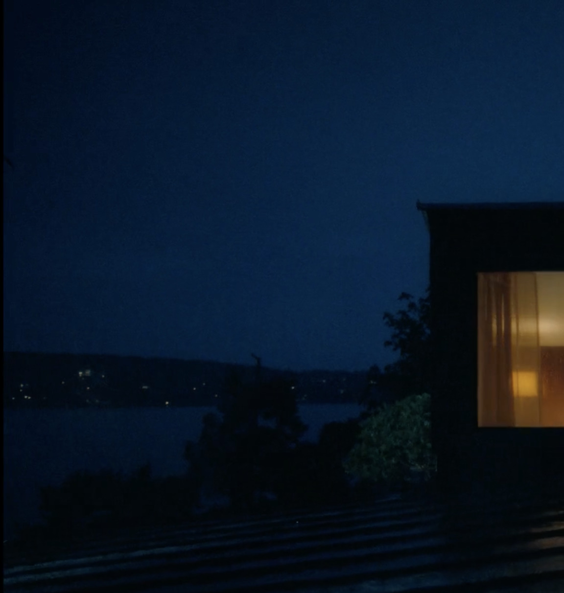 a couple of people standing outside of a building at night