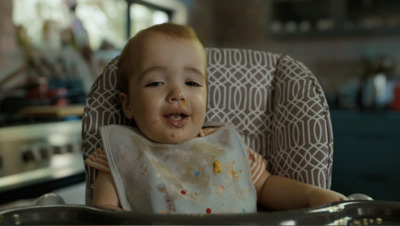 a baby sitting in a high chair with food on his face